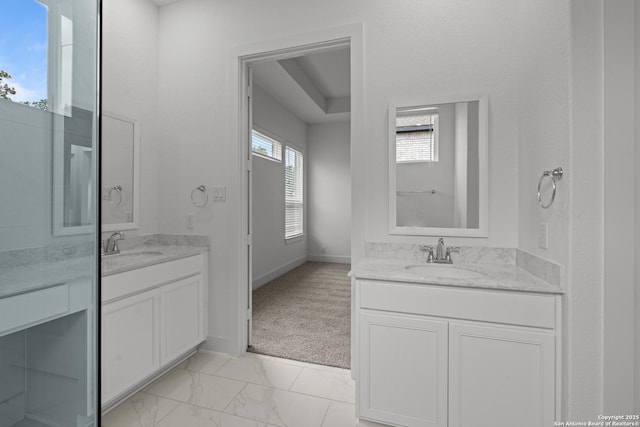 full bath with marble finish floor, two vanities, and a sink