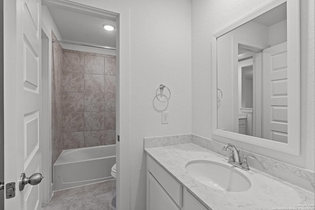 full bath with toilet, bathing tub / shower combination, vanity, and a textured wall