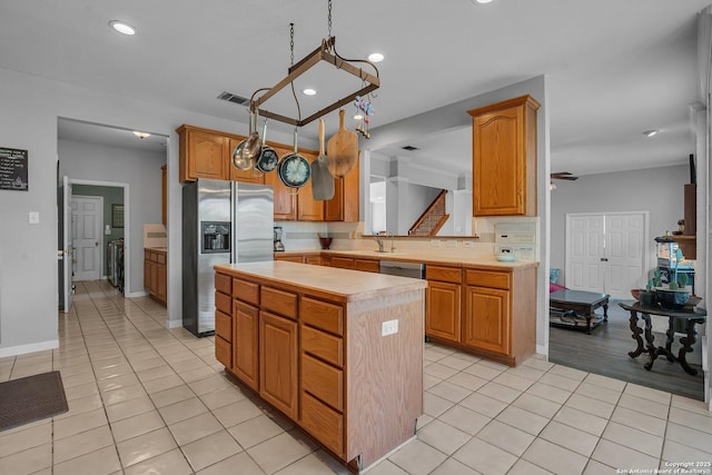 8114 Pimlico Ln, Boerne, TX 78015 - kitchen with visible vents, a kitchen island, light tile patterned flooring, light countertops, and stainless steel appliances
