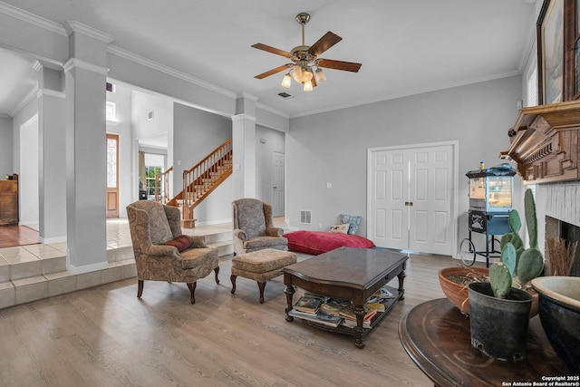 8114 Pimlico Ln, Boerne, TX 78015 - living room featuring crown molding, ornate columns, light wood-type flooring, a ceiling fan, and stairs