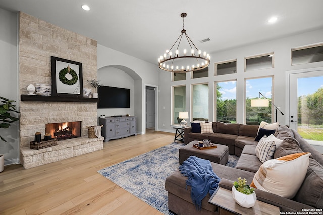 1064 Spanish Trl, New Braunfels, TX 78132 - living room with wood finished floors, an inviting chandelier, a stone fireplace, and recessed lighting
