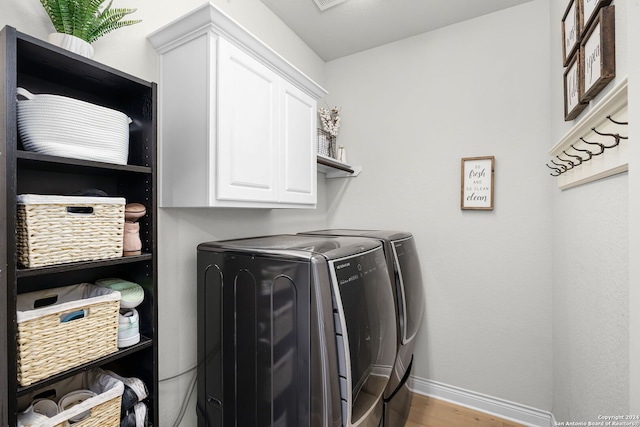 1064 Spanish Trl, New Braunfels, TX 78132 - clothes washing area featuring cabinet space, baseboards, washing machine and dryer, and wood finished floors