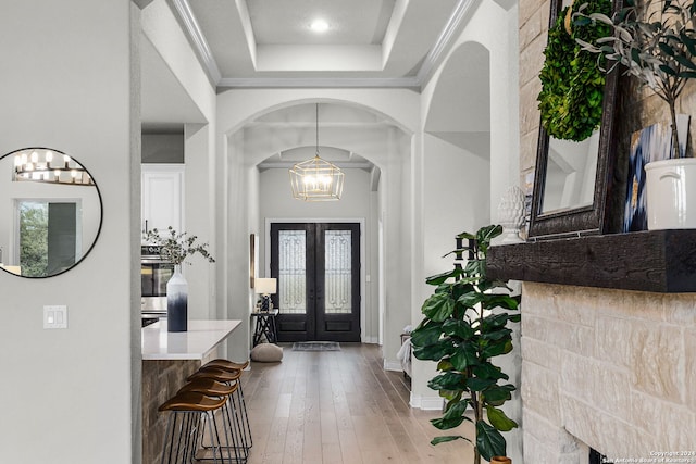 1064 Spanish Trl, New Braunfels, TX 78132 - foyer featuring arched walkways, a notable chandelier, a tray ceiling, french doors, and hardwood / wood-style floors