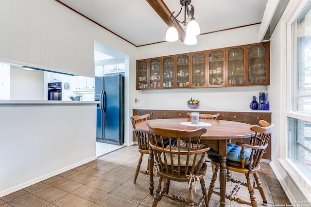 dining area featuring a notable chandelier, crown molding, and light tile patterned floors