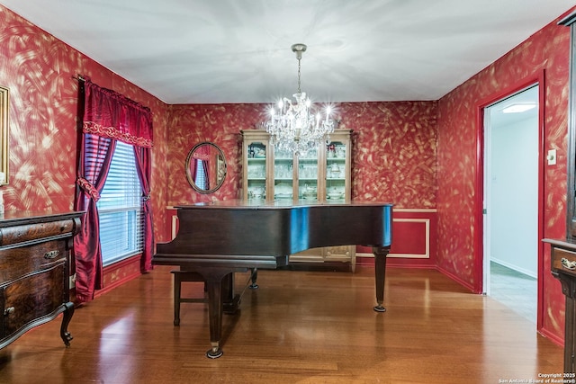 sitting room featuring an inviting chandelier, wood finished floors, and wallpapered walls