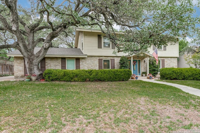 view of front of home with fence, a front lawn, and brick siding