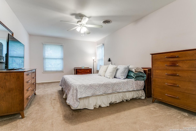 bedroom featuring ceiling fan, visible vents, and light colored carpet