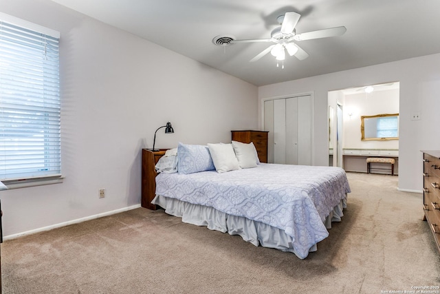 bedroom featuring a ceiling fan, a closet, light colored carpet, baseboards, and visible vents