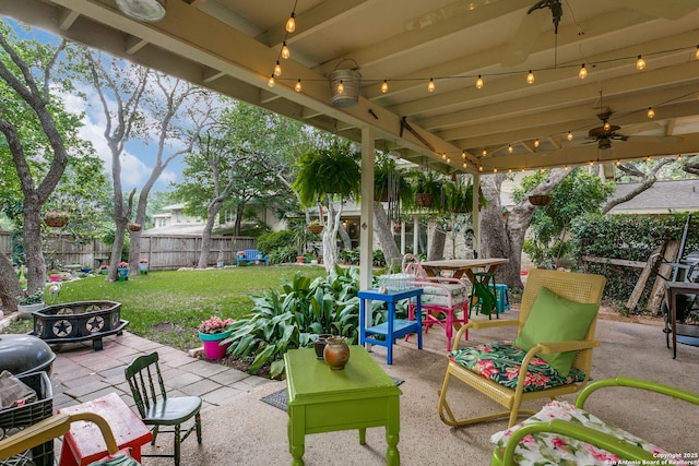 view of patio with ceiling fan, a fenced backyard, and an outdoor fire pit