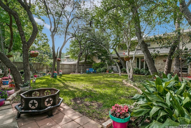 view of yard featuring fence and an outdoor fire pit