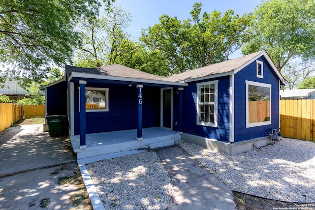 view of front of house featuring fence and covered porch