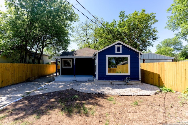 back of house featuring covered porch and fence private yard
