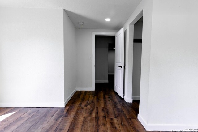 hallway with wood finished floors, baseboards, and recessed lighting
