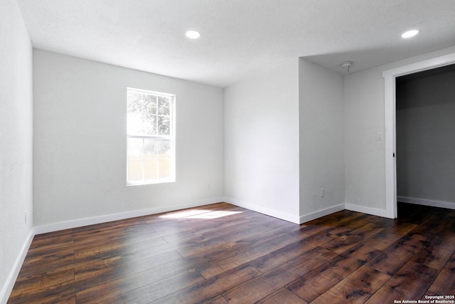 unfurnished room featuring recessed lighting, dark wood-style flooring, and baseboards