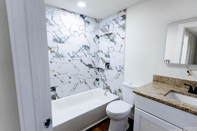 full bath with toilet, wood finished floors, vanity, and tub / shower combination