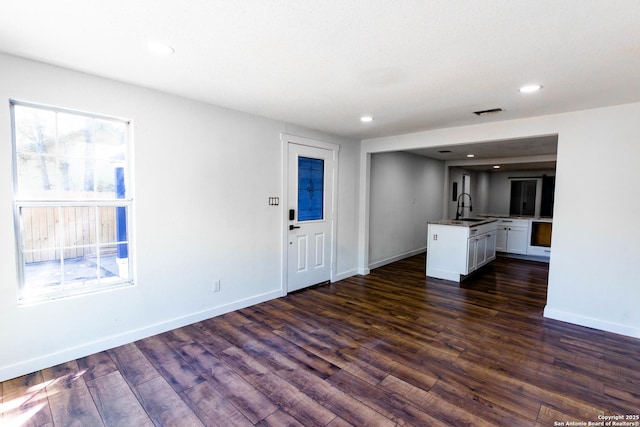 interior space with a sink, dark wood finished floors, baseboards, and recessed lighting