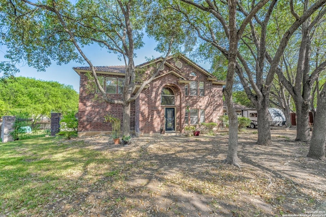 traditional-style home featuring a front yard and brick siding