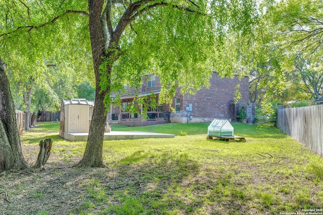 view of yard with a storage unit, a fenced backyard, and an outdoor structure
