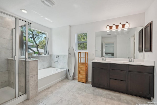 bathroom with a shower stall, plenty of natural light, a bath, and double vanity