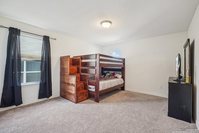 carpeted bedroom featuring baseboards and multiple windows