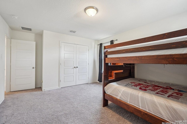 bedroom featuring carpet, visible vents, a closet, and baseboards