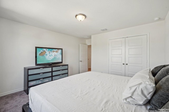 bedroom with carpet flooring, visible vents, a closet, and baseboards