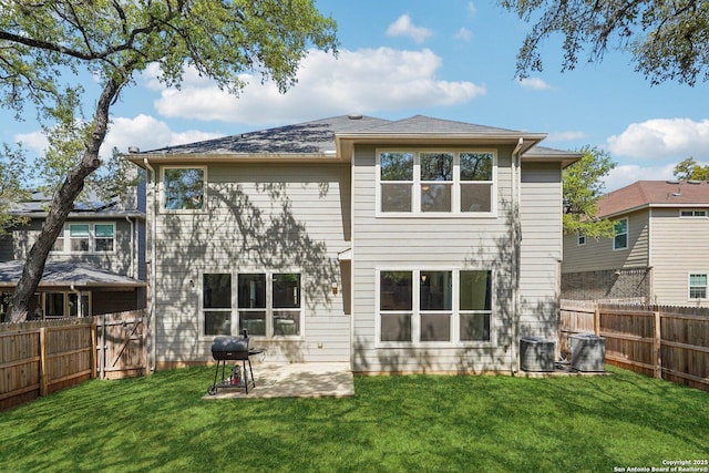 back of house featuring a yard, a fenced backyard, and central AC unit