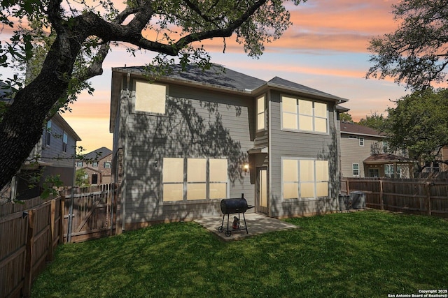 back of house with a yard, a fenced backyard, and a patio area