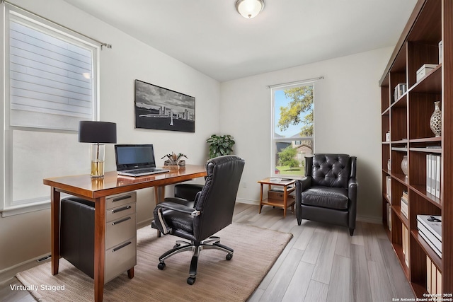 home office with light wood-style floors and baseboards