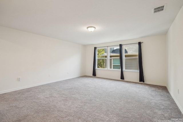 spare room with visible vents, baseboards, and carpet flooring