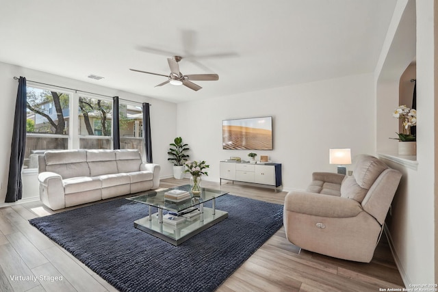 living room with wood finished floors, ceiling fan, baseboards, and visible vents