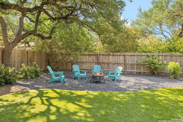 view of yard with a fenced backyard and a fire pit