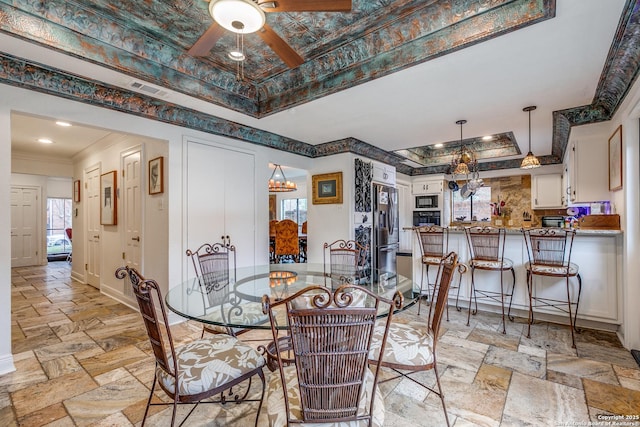 527 Thelma Dr, Olmos Park, TX 78212 - dining space with crown molding, ceiling fan, a tray ceiling, stone tile floors, and visible vents