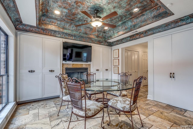 527 Thelma Dr, Olmos Park, TX 78212 - dining area featuring a fireplace, visible vents, a ceiling fan, and a raised ceiling