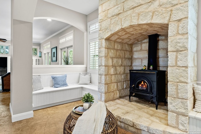 23954 Cibolo Vw, San Antonio, TX 78266 - living area featuring arched walkways, a wood stove, ornamental molding, and a wealth of natural light
