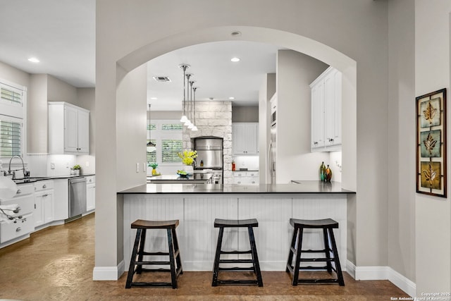 23954 Cibolo Vw, San Antonio, TX 78266 - kitchen featuring stainless steel dishwasher, arched walkways, a peninsula, and dark countertops