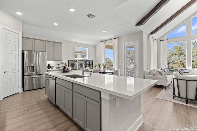 kitchen featuring light countertops, gray cabinetry, visible vents, stainless steel appliances, and a sink