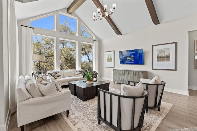 living room with high vaulted ceiling, beamed ceiling, light wood finished floors, a notable chandelier, and baseboards