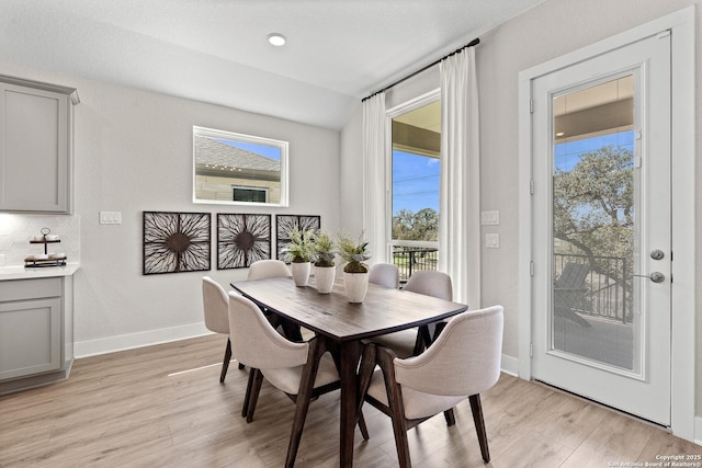 dining area featuring baseboards, light wood-type flooring, and a healthy amount of sunlight