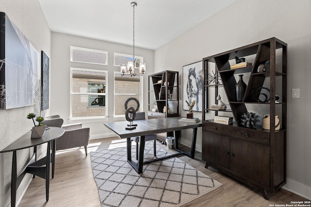 home office with baseboards, a chandelier, and light wood-style floors