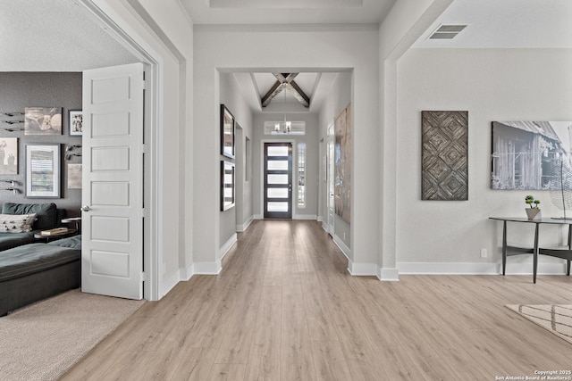entrance foyer with light wood-style flooring, an inviting chandelier, visible vents, and a wealth of natural light