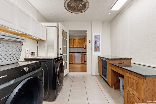 296 Wolf Ln, La Vernia, TX 78121 - laundry area featuring light tile patterned floors, independent washer and dryer, a textured ceiling, wine cooler, and cabinet space