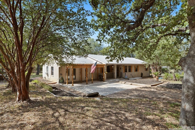 296 Wolf Ln, La Vernia, TX 78121 - rear view of house featuring brick siding and metal roof