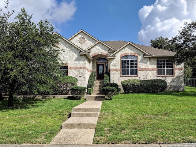 20918 Cactus Rdg, San Antonio, TX 78258 - view of front facade with a shingled roof, stone siding, and a front lawn