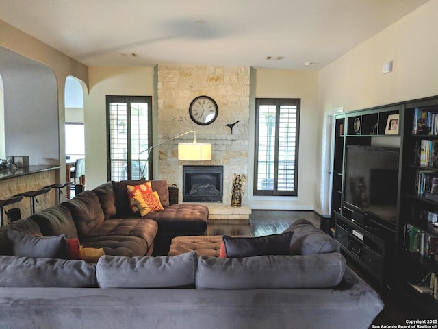 20918 Cactus Rdg, San Antonio, TX 78258 - living area with baseboards, a stone fireplace, dark wood-style floors, and visible vents