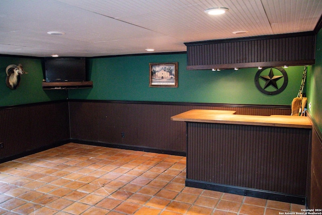 bar featuring light tile patterned floors, indoor bar, recessed lighting, and a wainscoted wall