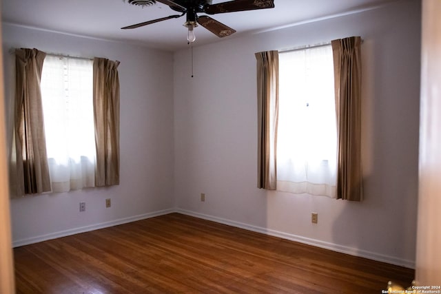 spare room with baseboards, a ceiling fan, and wood finished floors
