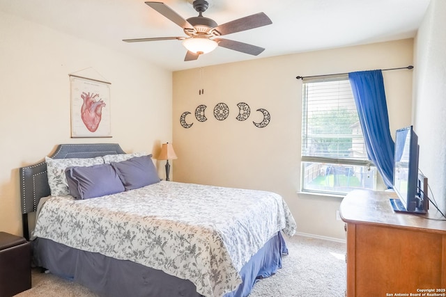 carpeted bedroom featuring baseboards and a ceiling fan