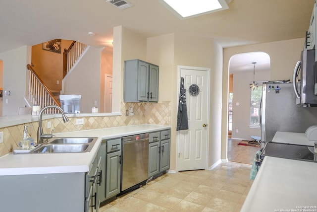 kitchen featuring tasteful backsplash, arched walkways, visible vents, appliances with stainless steel finishes, and a sink