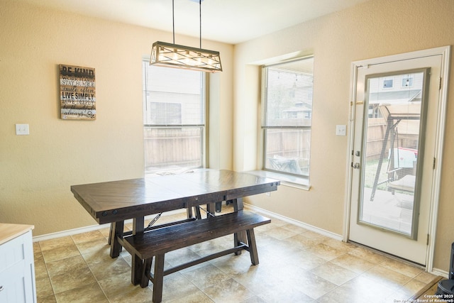 dining area featuring baseboards and a textured wall